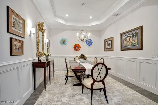 Dining or flex space with wide plank floors, crown molding, a tray ceiling, and an inviting chandelier | Image 7