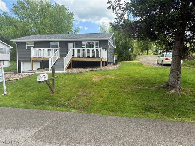 Single story home with an attached garage, a front yard, a deck, and driveway | Image 26