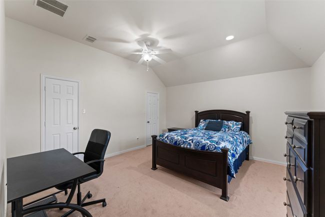 Bedroom featuring light carpet, lofted ceiling, a desk, and ceiling fan | Image 25