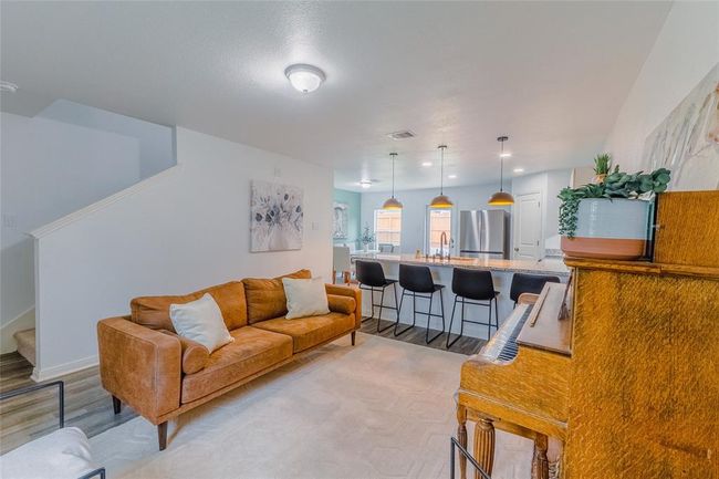 View from the opposite corner in the living room shows the staircase and a peek of the homes dining room. | Image 6