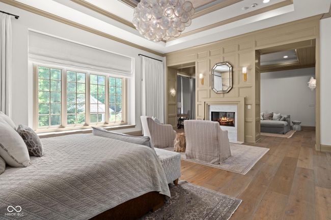 primary bedroom with ornamental molding, a chandelier, a premium fireplace | Image 23