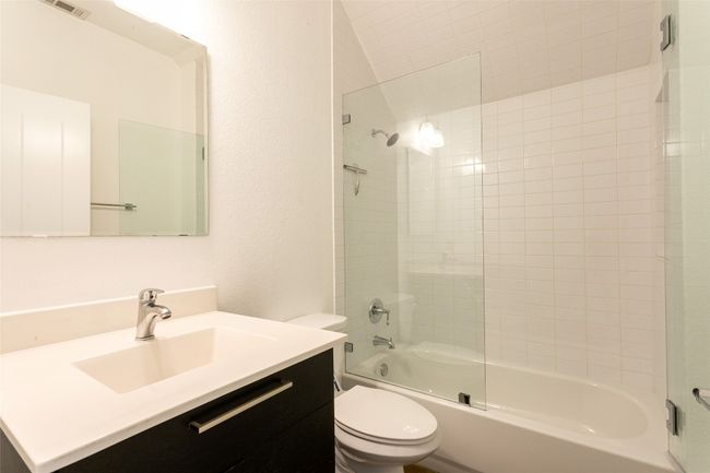Bathroom featuring vanity and shower / bath combination with glass door | Image 12