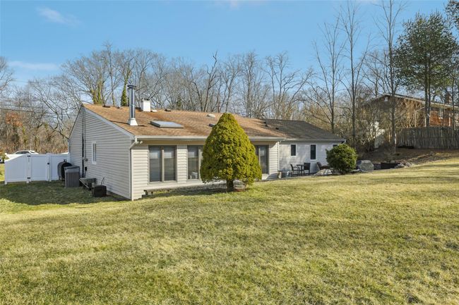 Rear view of house with a shingled roof, fence, a lawn, and a chimney | Image 29