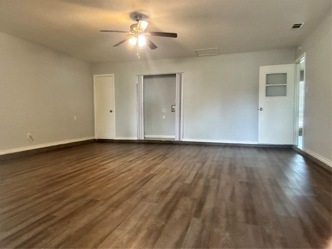 Empty room featuring dark wood-type flooring, a ceiling fan, and baseboards | Image 5