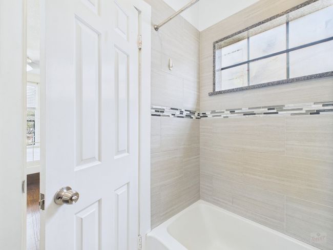 Bathroom featuring plenty of natural light and bathing tub / shower combination | Image 26