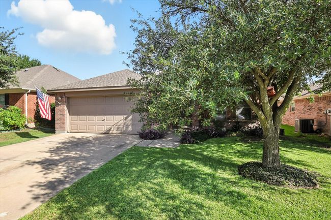 View of front of property featuring driveway, a shingled roof, brick siding, a garage, and a front lawn | Image 19