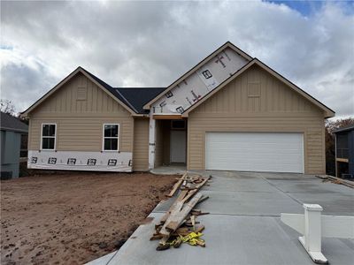 Reverse 1.5 story home with gable roof, 2-car garage, and sits on a beautiful treed lot. | Image 1