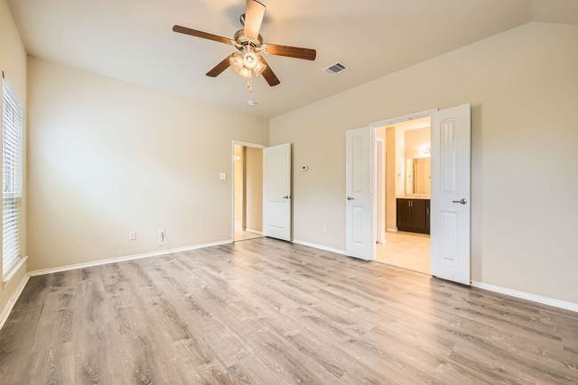 Unfurnished bedroom with light wood-type flooring, ensuite bathroom, and ceiling fan | Image 15