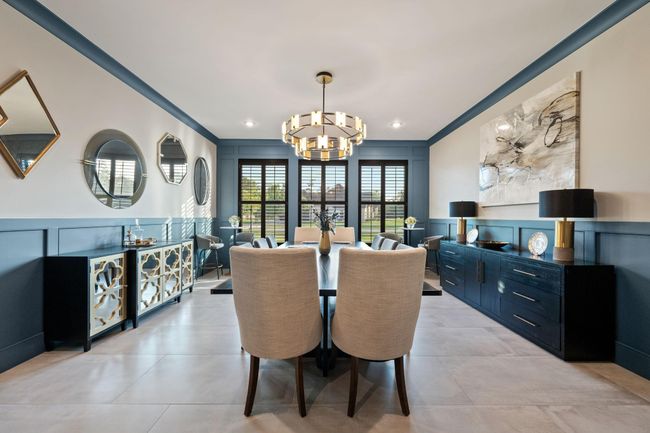 This elegant dining room features a modern chandelier with large windows providing abundant natural light. | Image 14