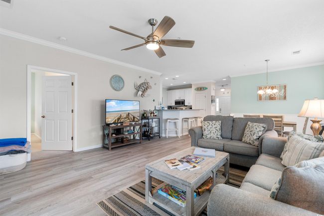 Living area featuring a chandelier, crown molding, light wood-style flooring, ceiling fan, and recessed lighting | Image 11