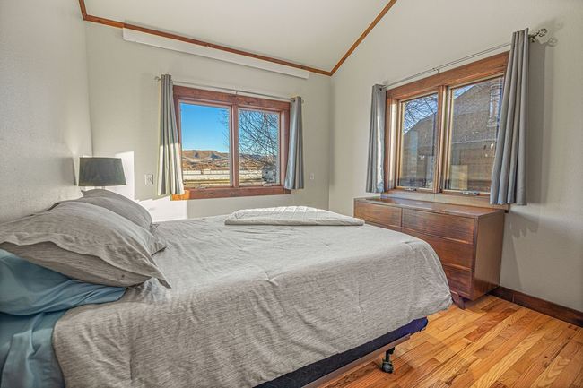 Bedroom featuring light wood-style floors, baseboards, vaulted ceiling, and ornamental molding | Image 20