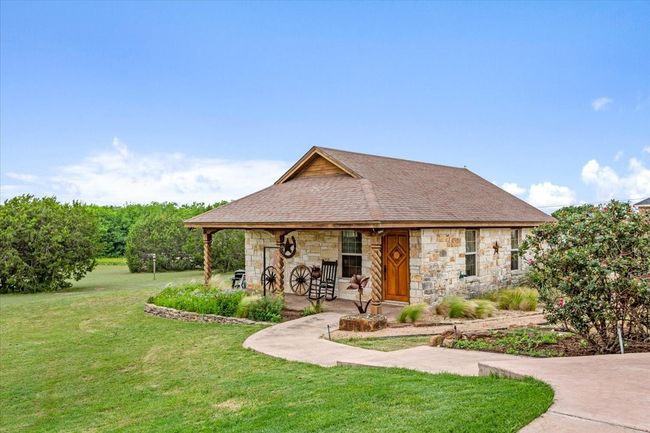 View of front of house featuring stone siding, a front lawn, and roof with shingles | Image 31