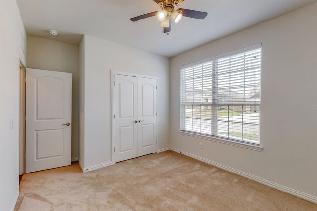 Unfurnished bedroom with light carpet, a closet, baseboards, and ceiling fan | Image 16