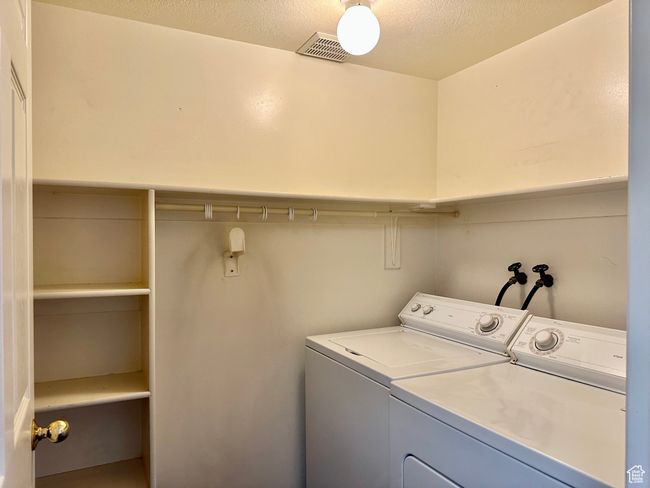 Laundry area featuring separate washer and dryer and ample shelves including a rod to hang clothes on | Image 24