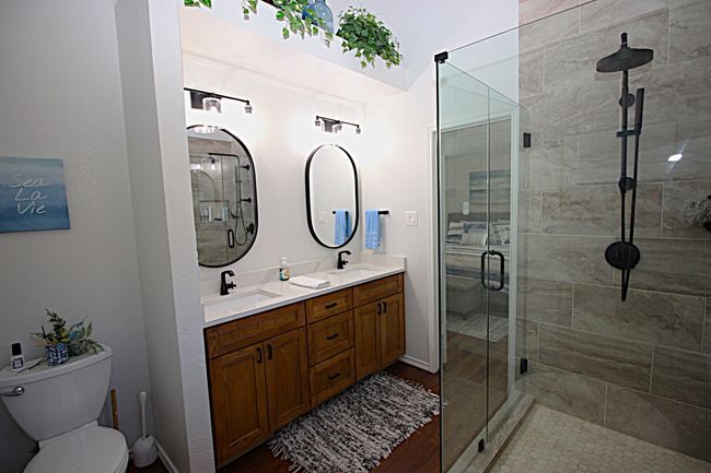 Bathroom featuring double vanity, toilet, a custom shower, and double sink | Image 33