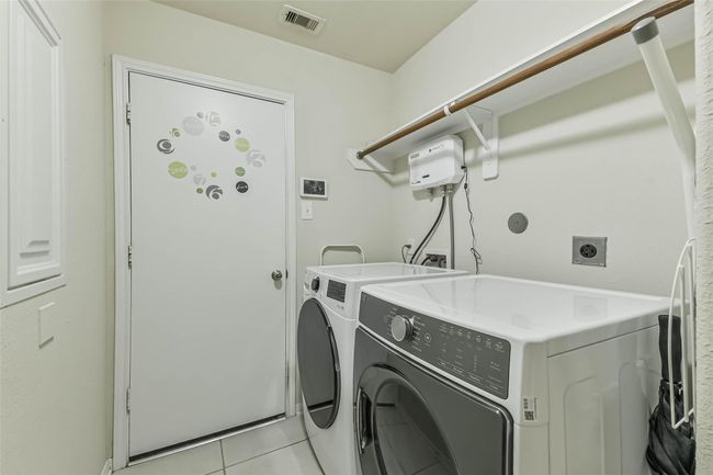 The utility room has access to the two-car garage and includes a LG 4.5 cu. ft. Front load washer with Turbo Wash 360 and built-in Intelligence and a STEAM DRYER by LG Dryer. | Image 30