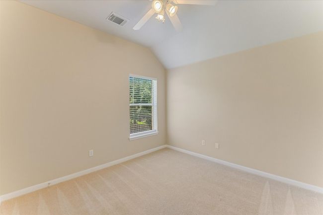 Empty room featuring lofted ceiling, light colored carpet, and ceiling fan | Image 16