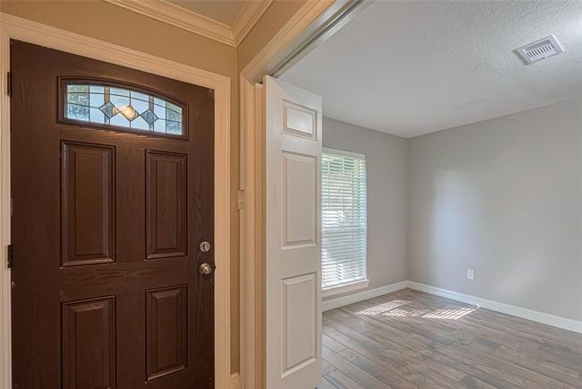 Front room off of entry offers lots of natural lighting, custom built-in wood cabinetry/desk, and double entry privacy doors that makes this perfect for office/study/hobby room | Image 4