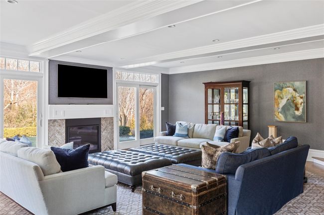 Living area with a wealth of natural light, a high end fireplace, and crown molding | Image 8