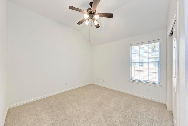 Empty room featuring ceiling fan, baseboards, carpet, and lofted ceiling | Image 27