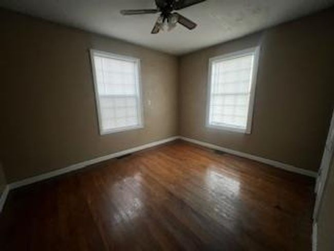 Empty room featuring wood finished floors, baseboards, and a ceiling fan | Image 9