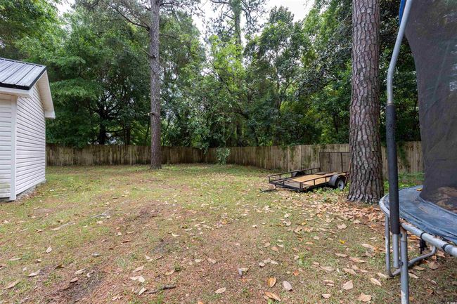 View of yard featuring a fenced backyard and a trampoline | Image 14