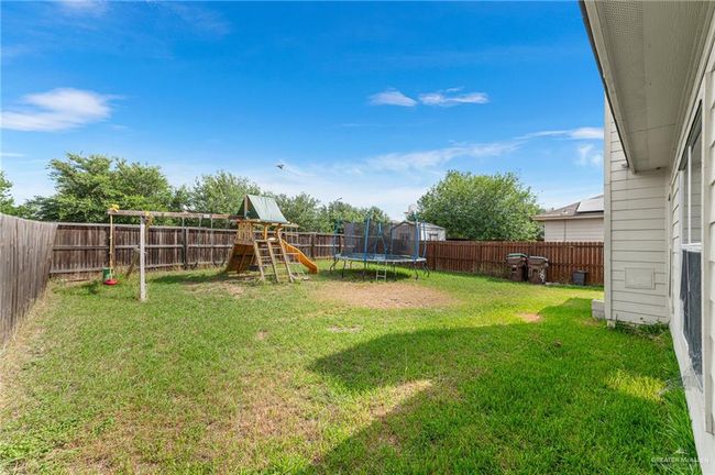Fenced backyard with a playground and a trampoline | Image 36