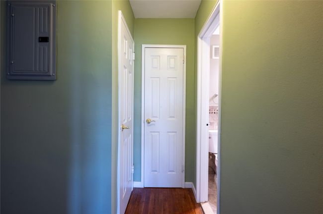 Hall with visible vents, dark wood-style flooring, baseboards, and electric panel | Image 12