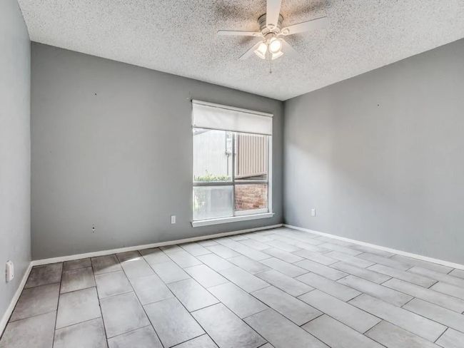 Tiled spare room featuring a textured ceiling and ceiling fan | Image 6