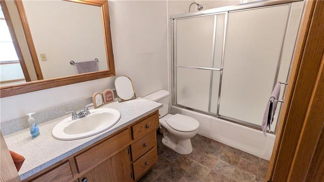 Full bathroom featuring vanity, toilet, and enclosed tub / shower combo | Image 23