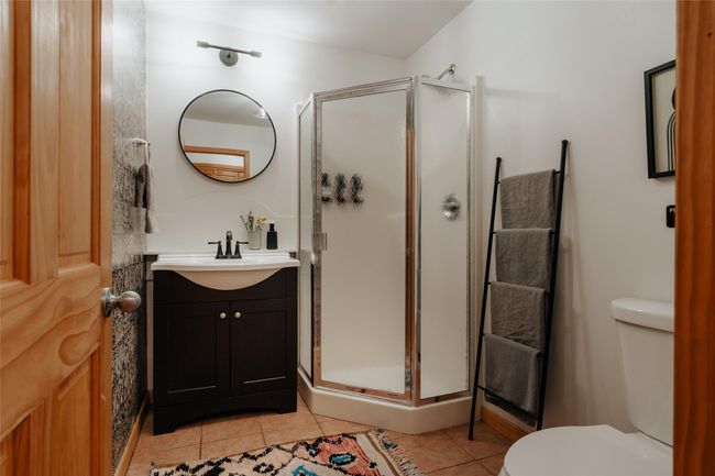 Bathroom with vanity, toilet, tile patterned floors, and a shower with shower door | Image 17
