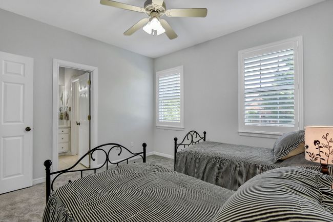 Carpeted bedroom with multiple windows and a ceiling fan | Image 23