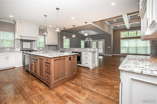 Kitchen with a kitchen island with sink, oven, backsplash, and recessed lighting | Image 9
