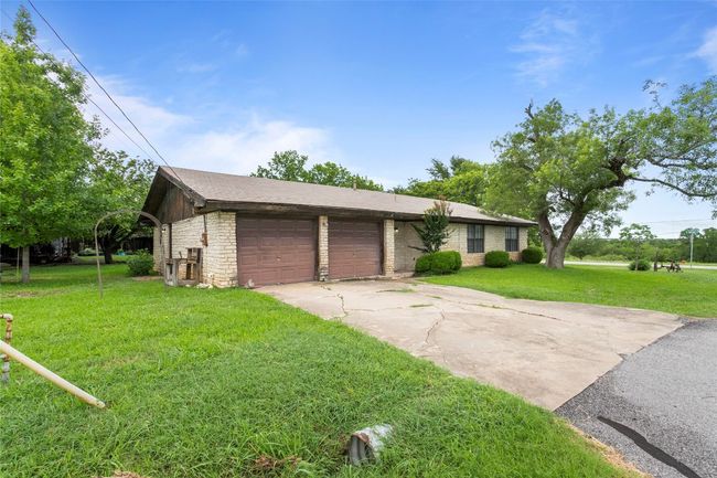 View of front of home with a front lawn, concrete driveway, and an attached garage | Image 6