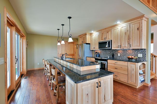 The eat-in kitchen has a nice long island with seating for many. | Image 23