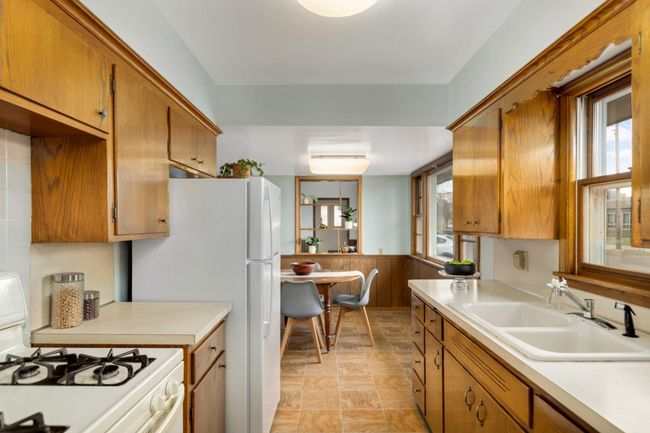 The kitchen has nice cupboard space and space to work. | Image 8