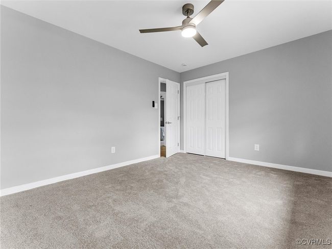Unfurnished bedroom with ceiling fan, a closet, carpet, and baseboards | Image 33