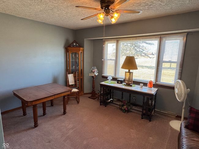 office featuring baseboards, carpet floors, a textured ceiling, and a ceiling fan | Image 18