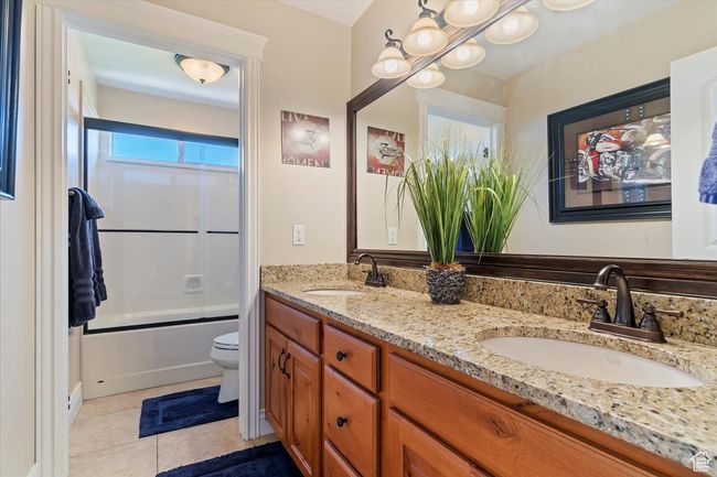 Full bath featuring a sink, tile patterned flooring, toilet, and double vanity | Image 41
