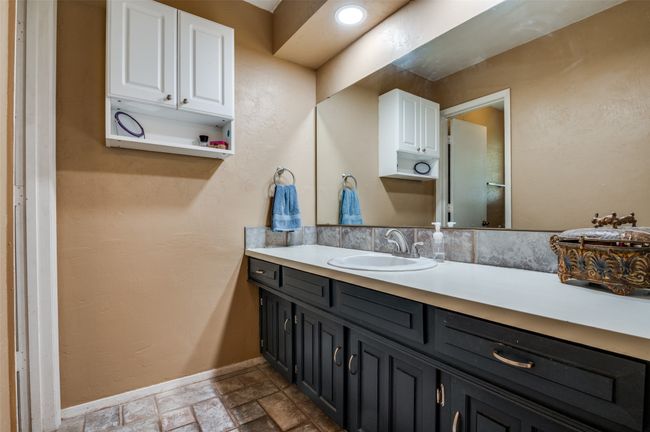 Bathroom featuring stone finish floor, baseboards, and vanity | Image 17