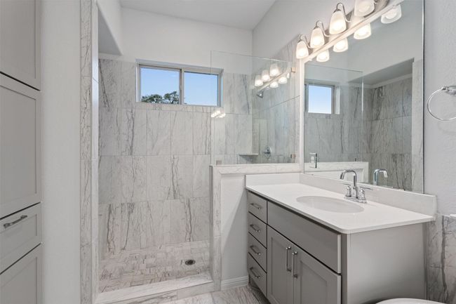 Full bathroom with marble finish floor, vanity, and walk in shower | Image 19
