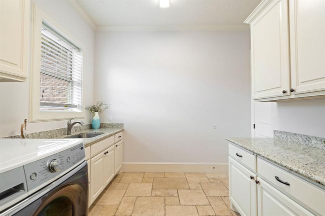 Another view of the Laundry Room shows additional storage space, making it easy to store all your cleaning products, stain fighters, and extra linens. Folding and sorting is made easier thanks to this large counter space separate from the sink. | Image 25