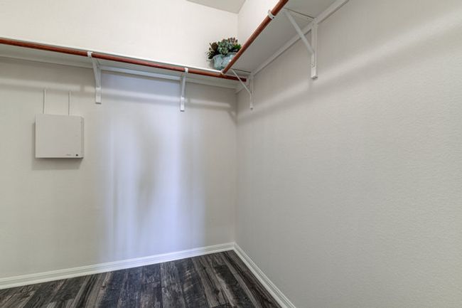 Spacious closet with dark wood-style floors | Image 12