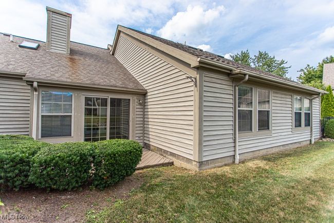 View of side of home with roof with shingles, a yard, and a chimney | Image 7