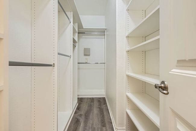 Spacious closet with dark wood-style flooring | Image 18