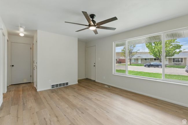 Unfurnished room with baseboards, a ceiling fan, visible vents, and light wood-style floors | Image 5