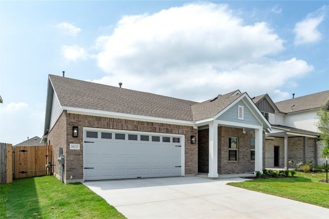 View of front facade with driveway, brick siding, an attached garage, a gate, and a shingled roof | Image 4