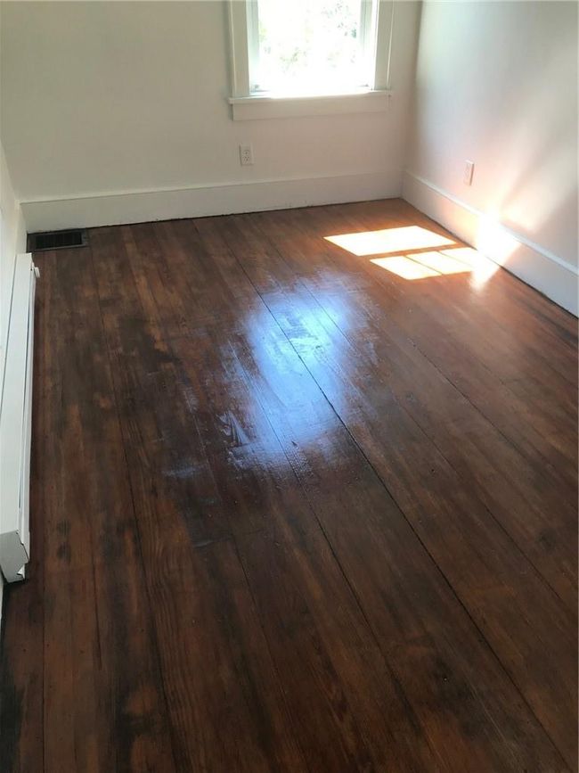 Unfurnished room featuring a baseboard heating unit and dark wood-type flooring | Image 25