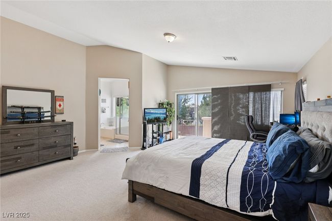 Carpeted bedroom with lofted ceiling, access to outside, and ensuite bathroom | Image 46