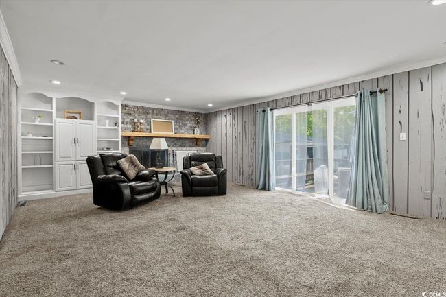 Living area featuring carpet flooring, a fireplace, crown molding, and recessed lighting | Image 10